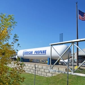 propane tank in a filed with a blue sky and an american flag